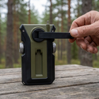 Närbild på en hand som vevar radions utfällda handvev på baksidan