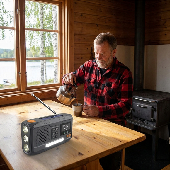 Man häller upp kaffe i stugköket med DAB+ radion på bordet och sjön utanför fönstret